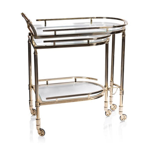 The SPIGA GOLD BAR CART by ZODAX features a vintage Italian-inspired design with elegant gold framing, mirrored glass shelves on both tiers, and smooth-rolling four-wheel mobility. Displayed against a white background, this piece is both stylish and functional.