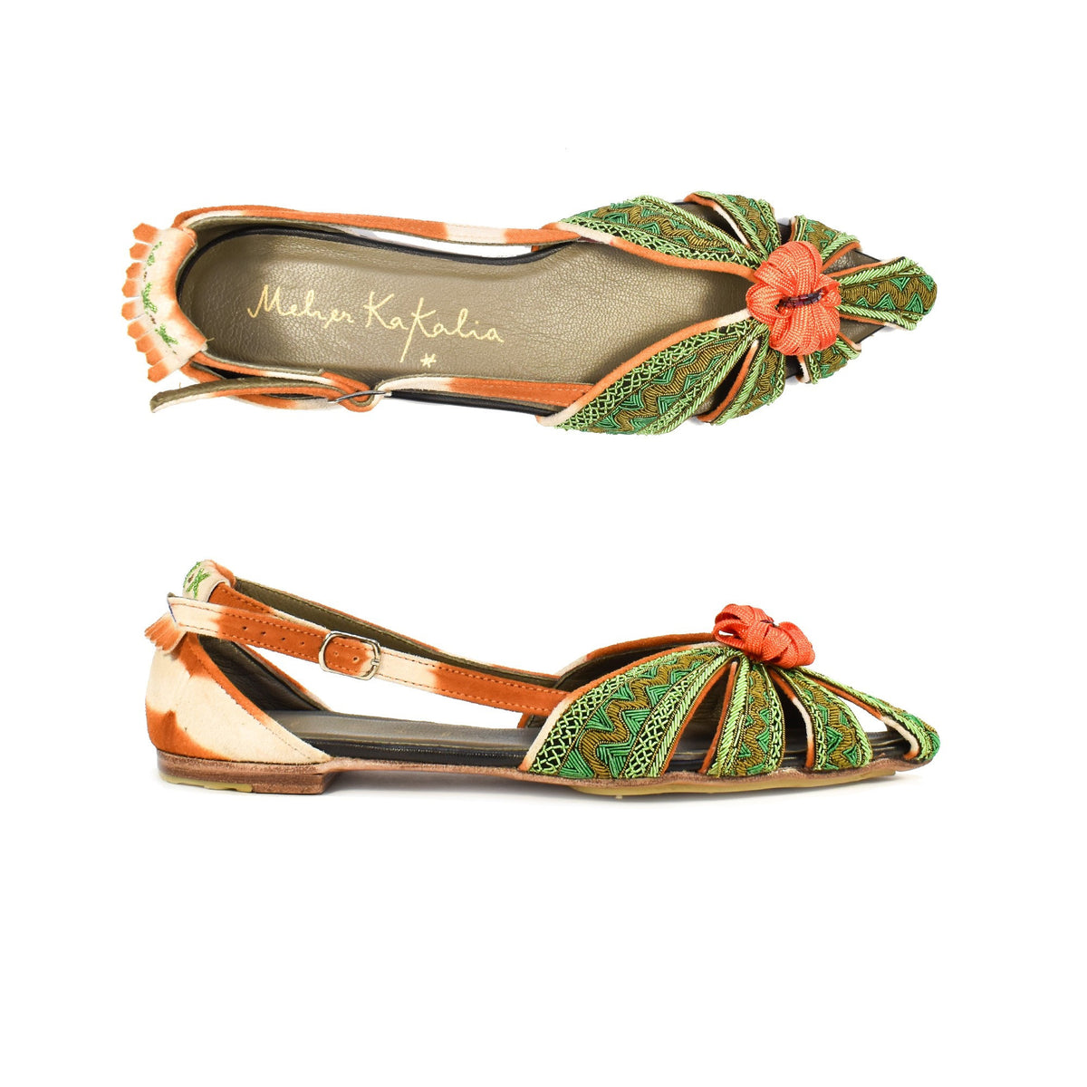 The MEHER KAKALIA - QUEEN DORIS SLING BACK IN HAWAIAN SANDS NILE flat shoe features intricate green stitching, open sides, and an orange strap. It is adorned with a vivid fabric flower on the toe and set against a neutral background for a striking effect.