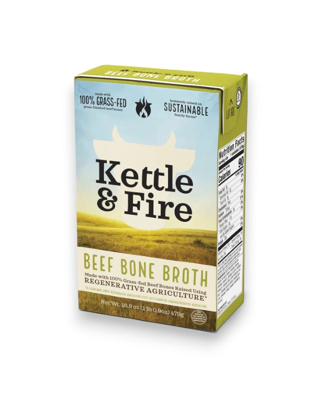 KETTLE &amp; FIRE - REGENERATIVE BEEF BONE BROTH carton, prominently displaying phrases such as "100% Grass-Fed," "Sustainable," "Made with 100% Grass-Fed Beef Bones," and "Regenerative Agriculture." The nutrition facts and ingredients lists are visible on the side. Net weight: 16.9 oz (1.06 pints). Ideal for those seeking quality bone broth from regenerative farms.