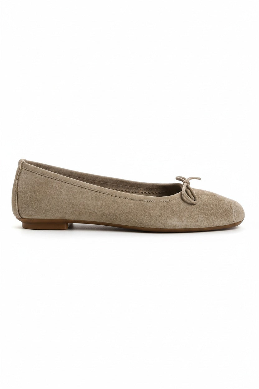 The REQINS - HARMONY BALLERINA FLATS by REQINS are shown in taupe suede with a small front bow and low heel, displayed in side profile against a plain light background.