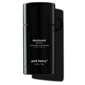 A person holds a black stick of JACK HENRY - DEODORANT HINOKI CYPRESS near their lips. Text highlights zinc ricinoleate, lactobacillus ferment, magnesium, and meadowfoam seed in this natural, aluminum-free JACK HENRY formula.