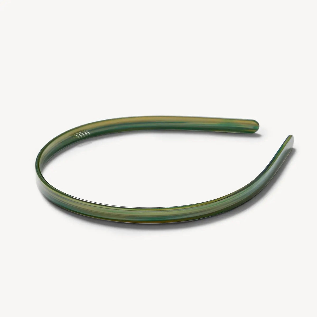 The MACHETE Ultralight Thin Headband in Meadow is a simple, slim green plastic accessory with a slight sheen, shown against a plain white background.