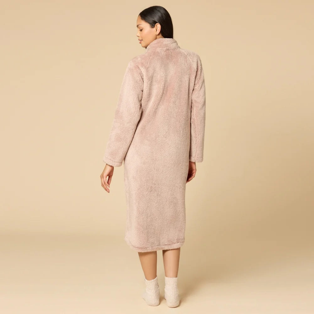 A woman wearing a blush-colored SOFTIES - DREAMPLUSH ZIP ROBE with matching knit socks.