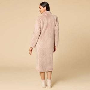 A woman wearing a blush-colored SOFTIES - DREAMPLUSH ZIP ROBE with matching knit socks.