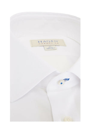 The HAGEN - COTTON DRESS SHIRT IN WHITE by HAGEN features premium cotton, a modern spread collar, white buttons, and a visible “Hagen Caremica” label inside the collar, displayed against a plain background.