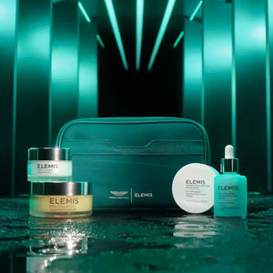 The ELEMIS - ASTON MARTIN ICONIC SKINCARE COLLECTION MEDIUM by ELEMIS - STEINER includes a jar, dropper bottle, cream container, and pump bottle in green and white packaging next to a matching pouch and box. Features their iconic cleansing balm.