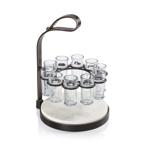 The ZODAX TEQUILERO 10 Shot Tequila Set with Marble Cutting Board is displayed on a table, featuring tequila bottles, lemon wedges, and clear iron-trimmed shot glasses against a dark textured background.