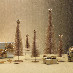 Five gold, tinsel-style TREASURE MOUNTAIN TREE 20″ decorative Christmas trees, structured like wire plant supports in varying heights with gold stars, arranged on a surface with wrapped gifts.