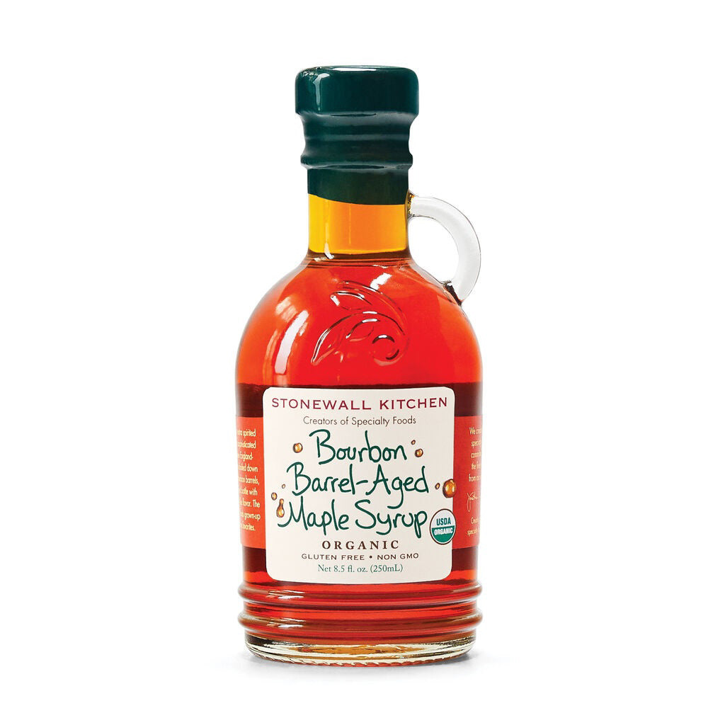 STONEWALL KITCHEN's Organic Bourbon Barrel-Aged Maple Syrup, featuring a rich amber hue and a caramel-like flavor, comes in a round bottle with a green cap and convenient loop handle for easy pouring. The white label, adorned with green and brown text, highlights key features like "Organic," "Gluten Free," and "Non-GMO.