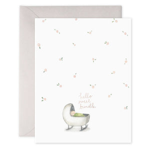 E. FRANCES PAPER - HELLO SWEET BUNDLE greeting card features a baby in a cradle with scattered pink flowers on a white background. The text "hello sweet bundle" is printed on heavyweight paper with gold foil accents, and the edge of the card is visible.
