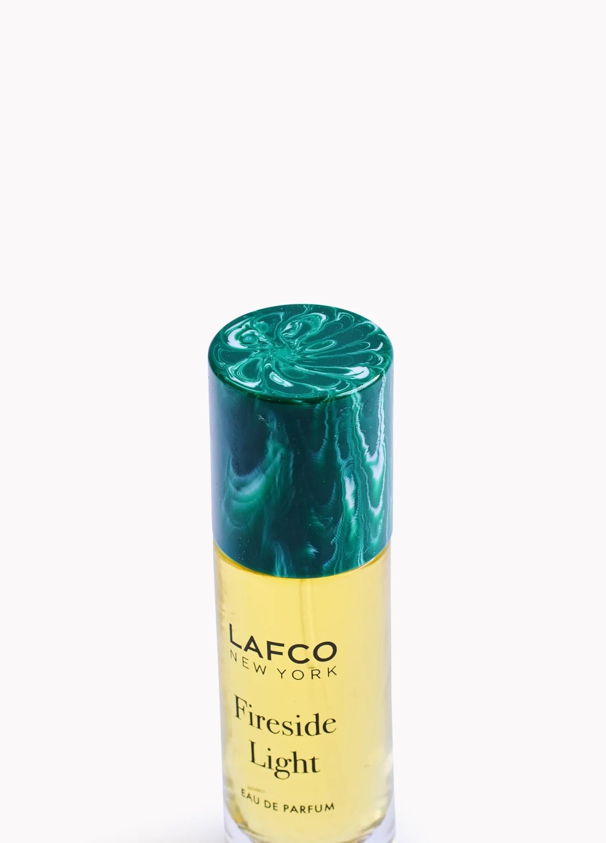 A yellow bottle of LAFCO - FINE FRAGRANCE, FIRESIDE LIGHT 10ML stands upright on a white background, featuring a marble-patterned green cap and reflecting the ambered vanilla notes of this vegan perfume.