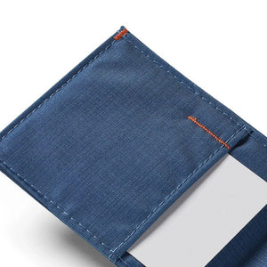 The ALLETT Sport Wallet in RFID-blocking indigo blue nylon features a minimalist design with an orange triangular logo on the corner, shown against a white background.
