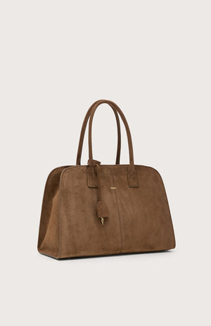 The SEVENTY VENEZIA suede leather bag in chocolate brown features two handles, a small padlock charm, and subtle gold branding on the front, displayed against a plain light background.