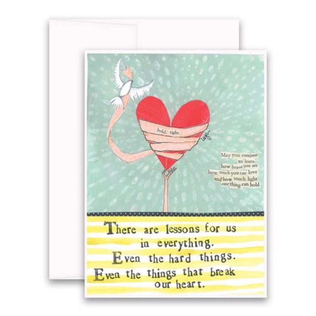 The CURLY GIRL DESIGNS – LIFE'S TOO SHORT CARD from CURLY GIRL DESIGN, INC features a collage art illustration of a bandaged red heart on a stick, held up by a bird. Beside the heart is a small poem that reads: "There are lessons for us in everything, even the hard things. Even the things that break our heart.