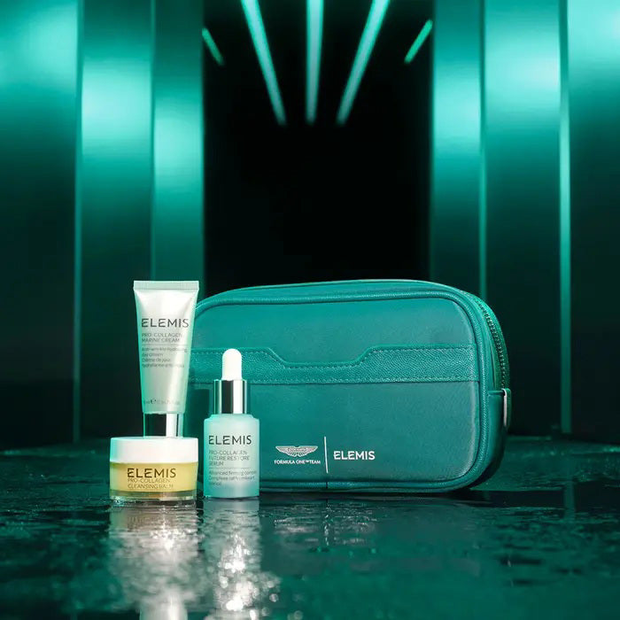 A green-themed ELEMIS - ASTON MARTIN ICONIC DISCOVERY SKINCARE COLLECTION by ELEMIS - STEINER includes travel-size skincare essentials in a box, zippered pouch, cream jar, tube, and dropper bottle, all shown on a white background.