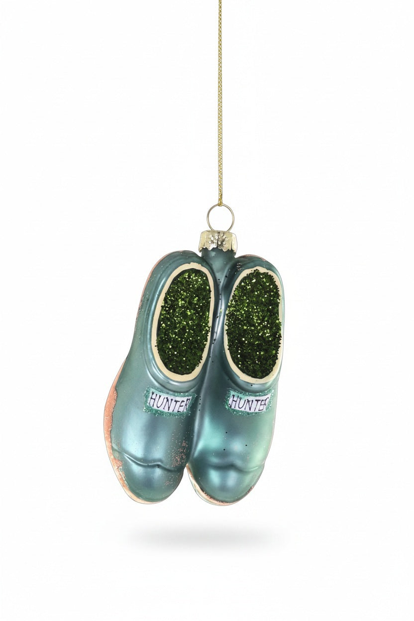 Cody Foster GARDNERS CLOGS ORNAMENT shaped like a pair of blue-green garden clogs with green glitter inside the openings and the word “HUNTER” on the front of each.