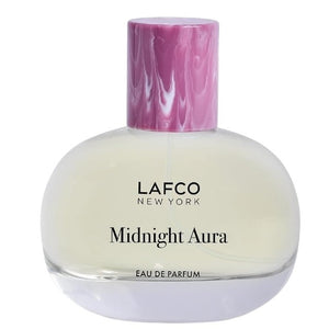 A LAFCO Fine Fragrance, Midnight Aura 50ml box rests on a rock, framed by flowers and green cactus pads in the background, capturing the essence of this alluring fruity perfume crafted with essential oils.