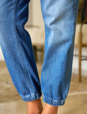 FRANK & EILEEN Jameson Utility Jogger Jean in 1968 Wash: light blue denim joggers with a mid-rise waistband, front patch pockets, and elastic cuffs at the ankles, shown flat on a white background.