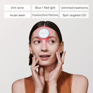 A round, white OMNILUX - BLEMISH ERASER KIT device from OMNILUX features a teal rim, power button, and logo; a soft pink light glows from underneath, showcasing its advanced blue and red light therapy technology.