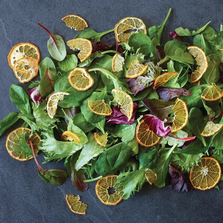 A clear plastic bag of DARDIMANS - CRISPY ORANGE SLICES by DARDIMANS CALIFORNIA CRISPS stands upright on a light surface—vitamin-rich snacks made from premium California oranges.