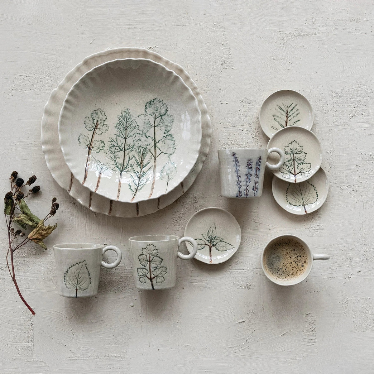 Four white HAND-PAINTED STONEWARE MUGS WITH BOTANICAL DESIGN from CREATIVE COOP are lined up side by side, each featuring unique flower and leaf illustrations and a comfortable round handle to brighten your morning routine.