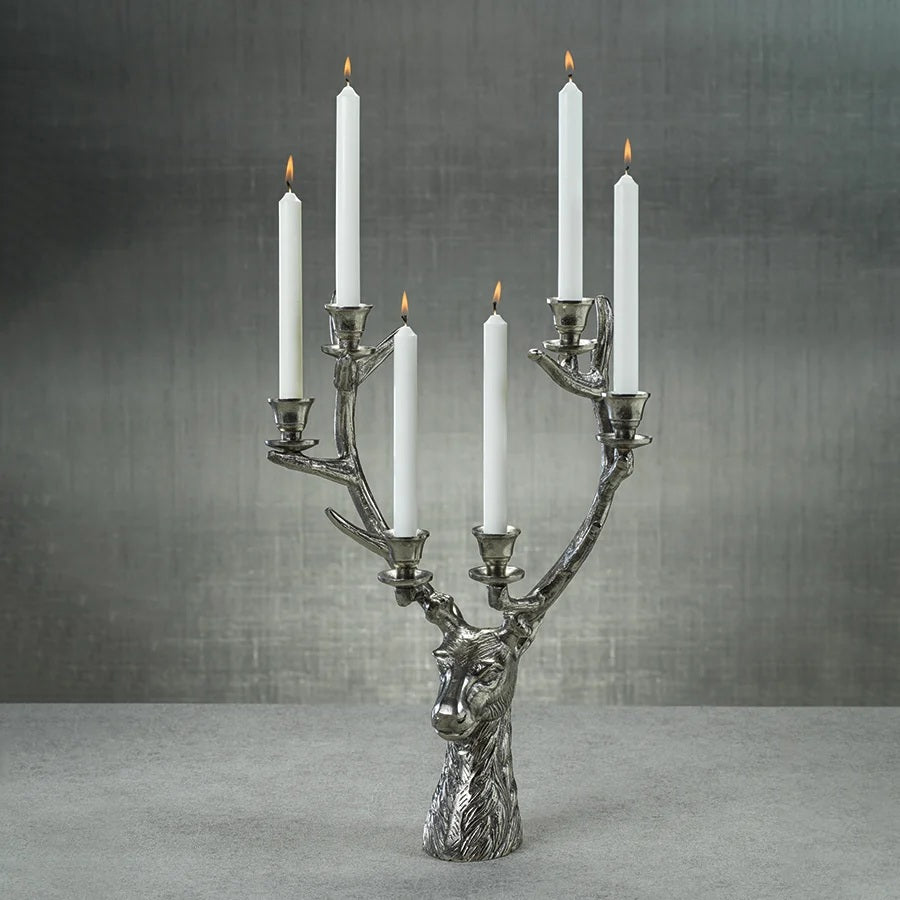 STAG HEAD 6 TIER CANDLEHOLDER IN SILVER ANTIQUE, a silver-toned alloy deer head statue featuring six candle holders positioned along its 16 in x 8 in x 24 in antlers.
