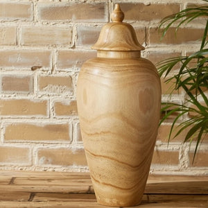 The PAULOWNIA WOOD COVERED TEMPLE JAR - SMALL by TWO'S COMPANY features a light brown paulownia wood construction with a rounded body, subtly narrow base, and a decorative lid. Its visible wood grain offers a natural and smooth look, making it an exotic accent piece for the home. The jar is shown standing upright against a white background.