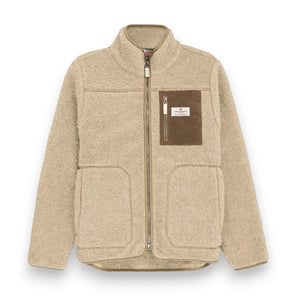 The AMUNDSEN SPORTS - HEROES WOOL FLEECE JACKET is a beige sherpa fleece zip-up with a high collar, large front pockets, and a contrasting waxed cotton chest pocket with a white label, offering a cozy, casual look.