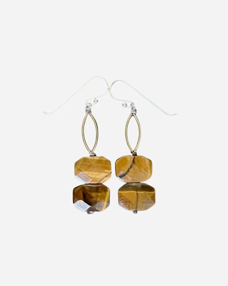 ANN LIGHTFOOT Tiger Eye Faceted Double Drop Rectangle Earrings feature gold and brown stones with brass connectors, hanging from sterling silver earwires. Shown on a soft, textured, light beige fabric background.