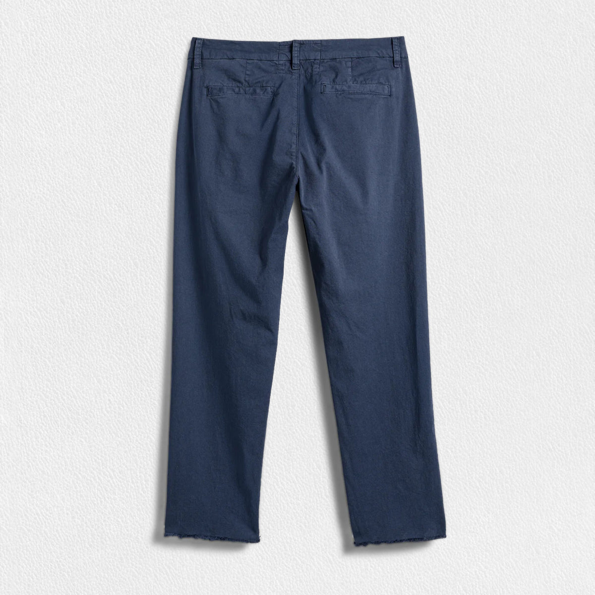 A pair of FRANK &amp; EILEEN’s THE WICKLOW Italian Chinos in Performance Twill, featuring a navy blue color, straight legs, and raw unfinished hems, is laid flat on a light textured background for an Italy-meets-California vibe.