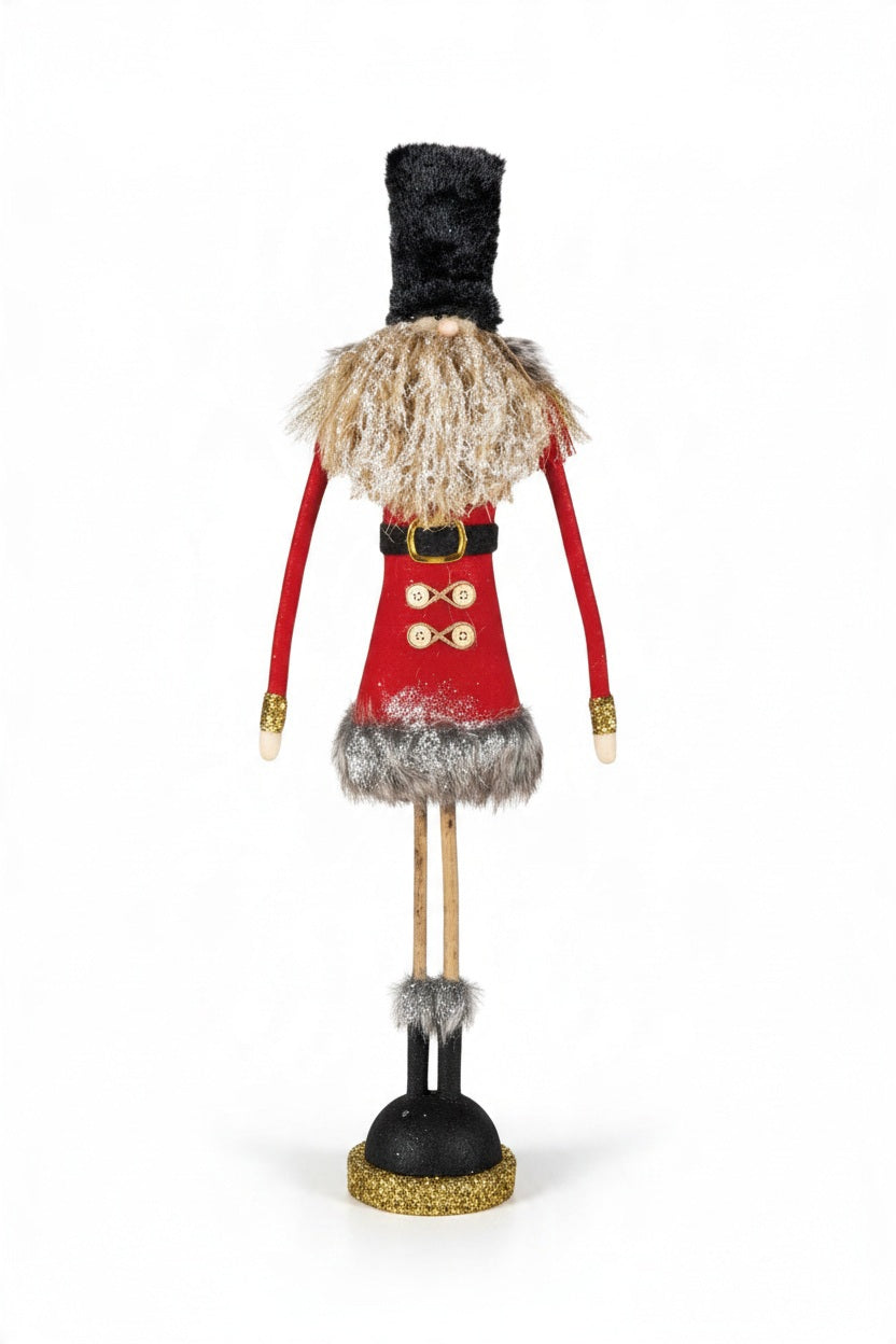 Two decorated gold tinsel Christmas trees stand next to two FABRIC SOLDIER WITH GLITTER, FAUX FUR AND TWIG LEGS figurines.
