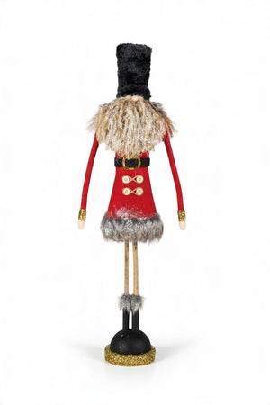 Two decorated gold tinsel Christmas trees stand next to two FABRIC SOLDIER WITH GLITTER, FAUX FUR AND TWIG LEGS figurines.