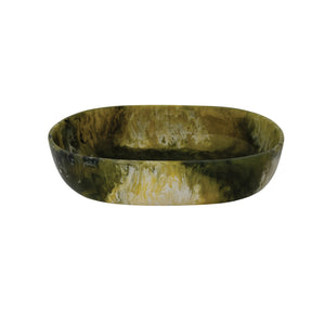 The GREEN MARBLED RESIN BOWL by CREATIVE COOP features an oval shape and a glossy marbled pattern in dark green, yellow, and white—ideal as a modern accent piece for your space.