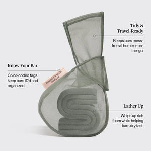A green, eco-friendly mesh bag from KITSCH sits beside green packaging labeled “KITSCH - ROSEMARY & BIOTIN SHAMPOO BAR SAVER BAG,” designed for storing solid shampoo bars and extending their lifespan. A pink tag reads “Rosemary & Biotin Shampoo Bar.” Both the bag and box are displayed against a white background.