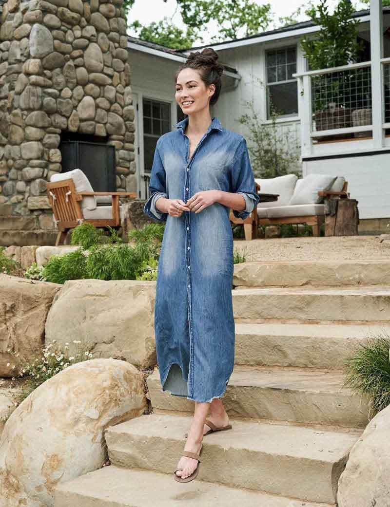 The FRANK &amp; EILEEN Rory Maxi Shirtdress in Famous Denim is a full-length button-up dress featuring a collar, rolled-up sleeves to mid-length, and a single chest pocket. Its sleek, minimalist design embodies that California chic look against a plain white textured background.
