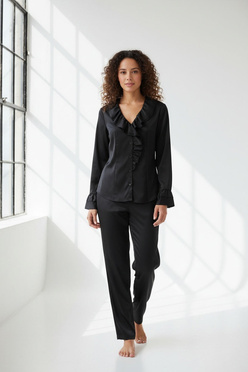A woman with long dark hair wears the HINSON WU AMARA Long Sleeve Cotton Satin Shirt, featuring ruffled details on the collar and front, standing against a plain light background.