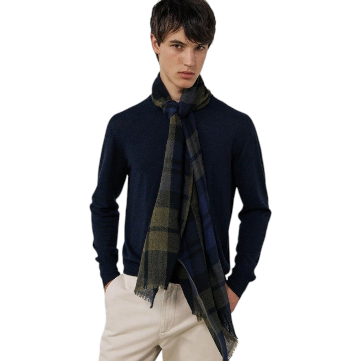 A young person with short dark hair wears a navy sweater and the HARTFORD Tartan Wool Scarf in Navy, Indigo, and Olive from HARTFORD, tied loosely around their neck, looking directly at the camera against a plain light background.