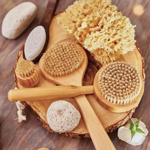 A boxed BAUDELAIRE Bath Sea Sponge Gift Box, Small, rests on a table, partially opened to display the natural yellow bath sponge inside. The packaging showcases vintage-style illustrations and text, while a bottle and another sponge appear blurred in the background.