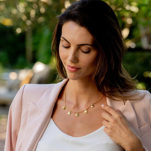 The CAPUCINE DE WULF - LOVE HEART MULTI STATION necklace by CAPUCINE DE WULF is a delicate piece handcrafted with 18K gold plating, featuring five small, textured heart-shaped charms evenly spaced along the front for a timeless and elegant look.
