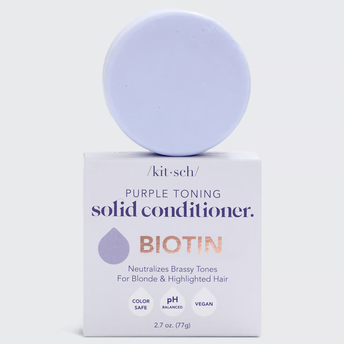 A KITSCH Purple Toning Solid Conditioner Bar sits on its packaging, which states it's formulated with Biotin for blonde and highlighted hair, neutralizing brassiness. The labels affirm it's color safe, pH balanced, and vegan.