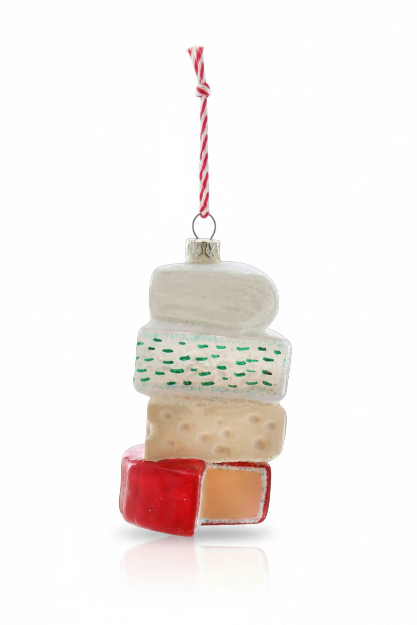 A fun gift for design lovers and collectors, the CHEESE STACK ORNAMENT by CODY FOSTER displays four colorful cheeses stacked and hanging from a festive red and white string—perfect for your holiday décor.