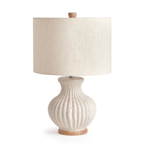 The NAPA HOME AND GARDEN - MARGOT LAMP features a textured, ribbed off-white ceramic base, round wooden bottom, beige linen drum shade, and a small wooden finial for a warm, natural touch.