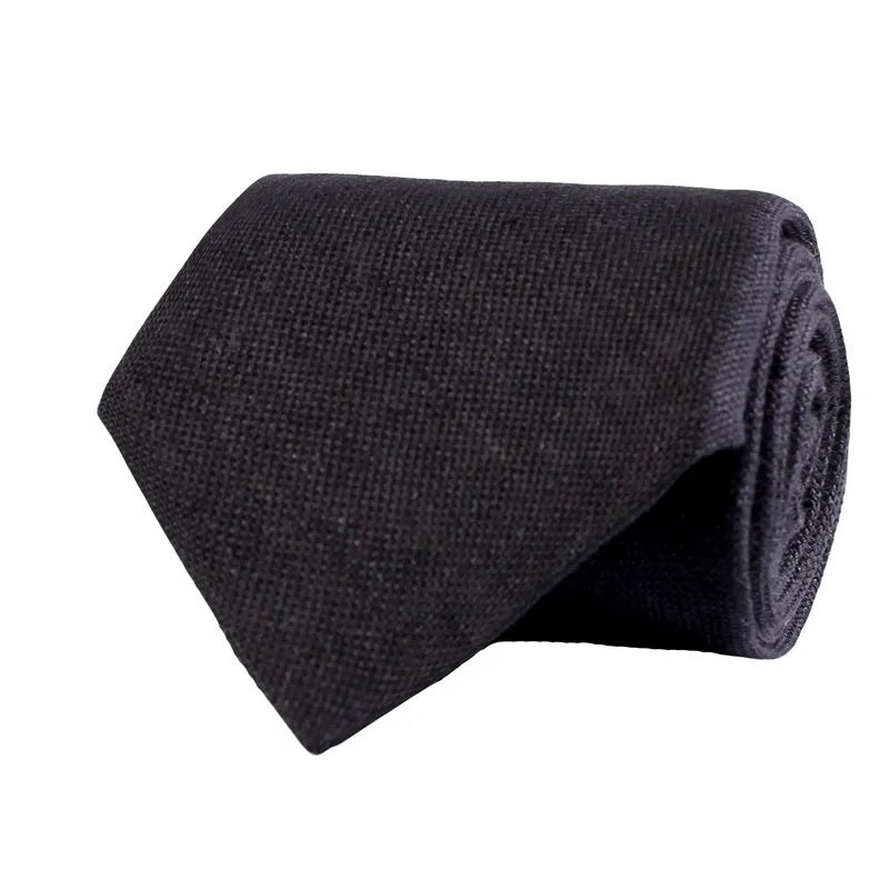 The AMANDA CHRISTENSEN Jacquard Linen Tie in Black, a classic men’s accessory from AMANDA CHRISTENSEN, is neatly rolled and displayed against a white background.