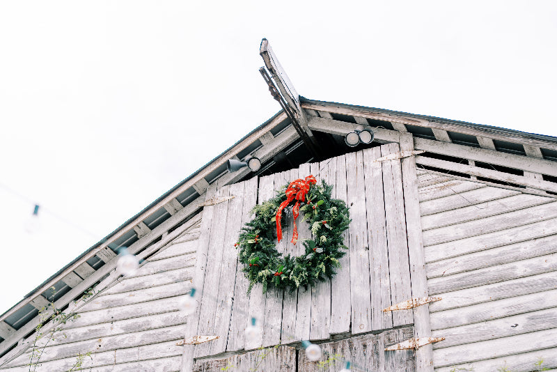 Wreath with a red bow on the front of the fearrington barn