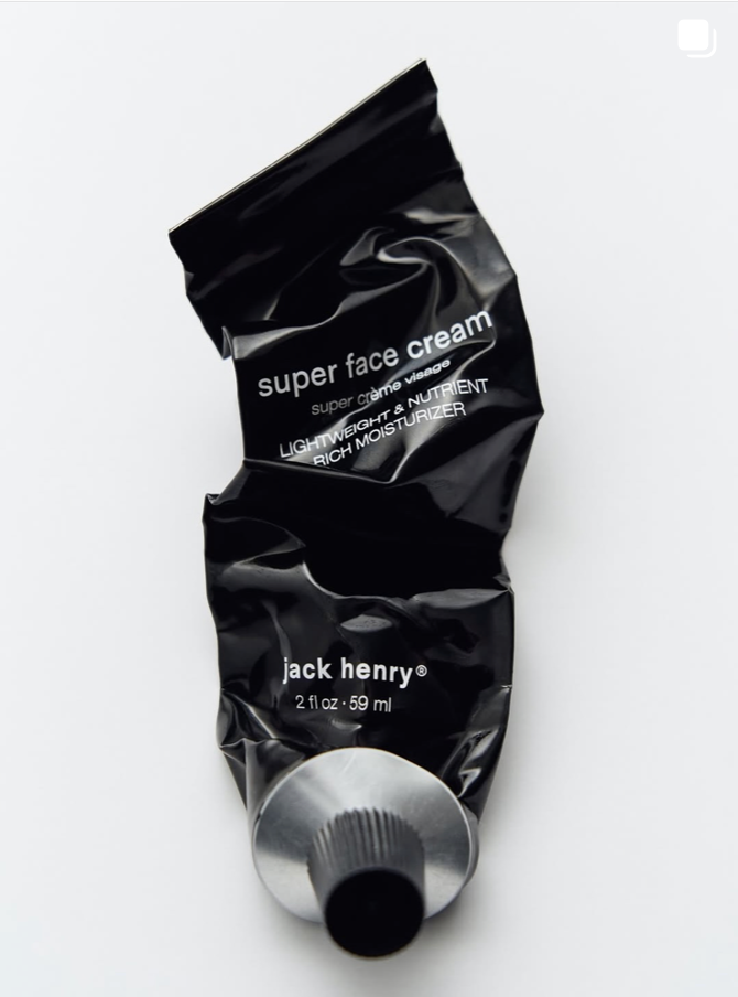 A black, crumpled tube labeled 