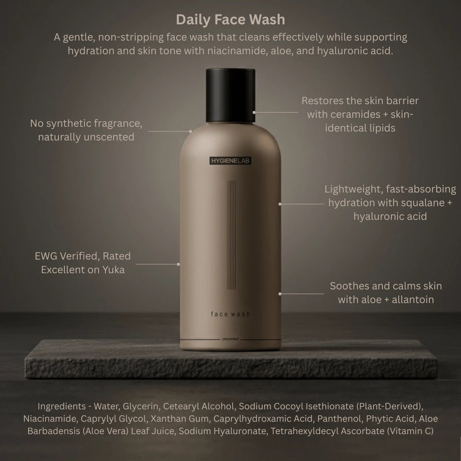 A person dispenses HYGIENELAB - FACE WASH, UNSCENTED from a brown bottle onto their open palm against a neutral background.