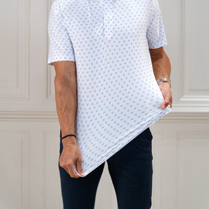 The COLLARS AND CO FEATHERWEIGHT FLEX POLO IN ORACLE WHITE features white fabric with a repeating pattern of small blue 3x3 dot squares. Slightly creased at the center, its 6-way stretch design ensures all-day comfort.