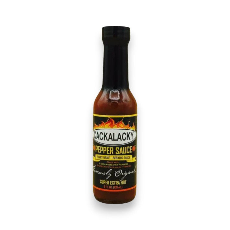 A bottle of CACKALACKY - PEPPER SUPER EXTRA HOT sauce by CACKALACKY, featuring a black cap and label with flames and "Super Extra Hot" text. The bottle contains reddish-brown Carolina reaper pepper sauce.