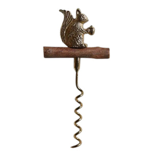 The BE HOME - SQUIRREL CORKSCREW by BE HOME, INC features a brown branch handle and a metallic squirrel with an acorn, adding woodland charm to your bar—perfect as a unique hostess gift. Shown on a light textured background.