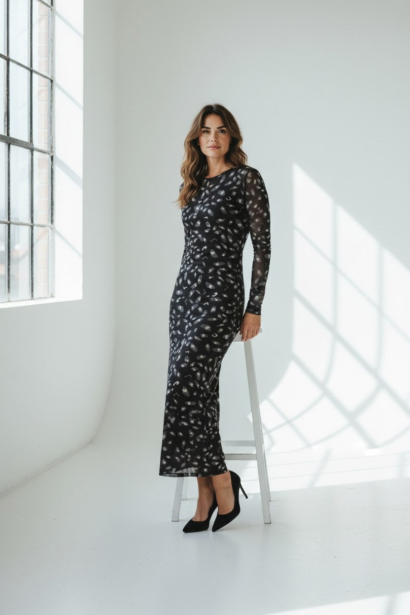 The FRANCO FERRARI BALLET MESH MAXI DRESS is a long-sleeved, ankle-length black stretch mesh dress with a sheer overlay featuring scattered gray and white abstract patterns, shown against a white background.